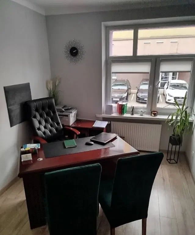 Pokój przyjęć klientów z zielonymi welurowymi fotelami i oknem